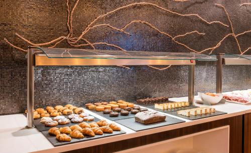 a display case filled with lots of different types of donuts at Ilunion Pio XII in Madrid
