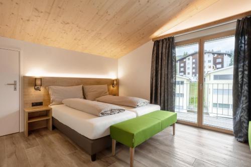 FlumserbergにあるHotel Tannenbodenのベッドルーム1室(ベッド1台、大きな窓付)