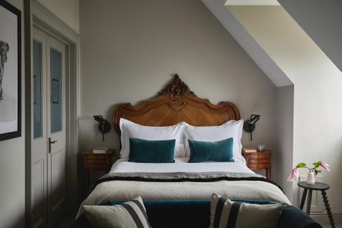 a bedroom with a large bed with blue and white pillows at Fowey Hall Hotel in Fowey