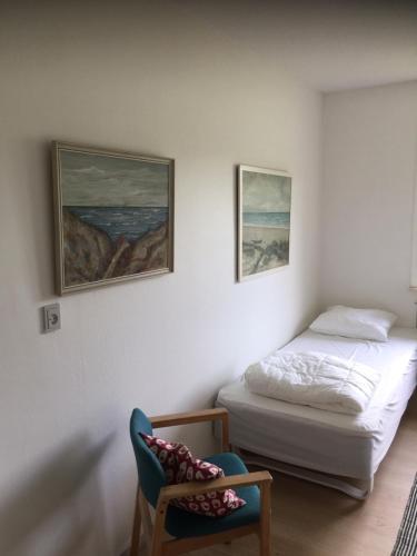 a small bedroom with a bed and a chair at Aktivitetshuset Solhjem in Hjørring