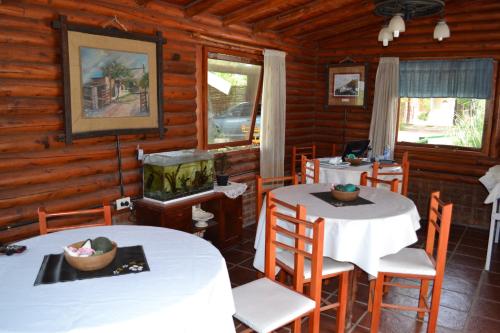 un comedor con mesas y sillas en una cabaña de madera en Las Esmeraldas en Nono