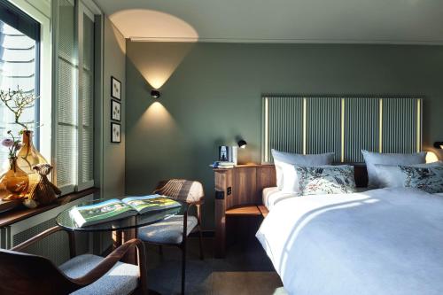 a bedroom with a bed and a table and a chair at Parkhotel Gütersloh in Gütersloh