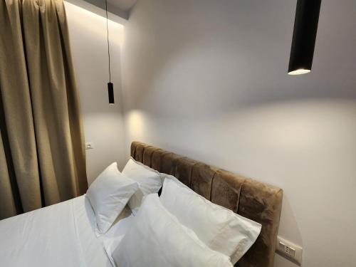 - une chambre avec un lit doté de draps et d'oreillers blancs dans l'établissement Sea Front Villa, à Vlorë