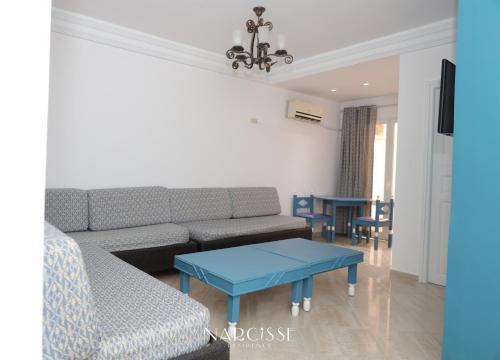 a living room with a couch and a table at NARCISSE RESIDENCE in Hammam Sousse