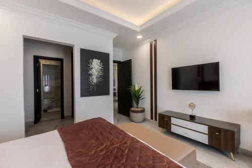 a bedroom with a large bed and a flat screen tv at Gewan White Beach Resort-New Alamein in Marsa Matruh