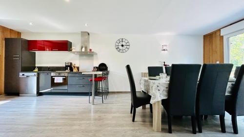 a kitchen and dining room with a table and chairs at Chalet avec terrasse sur pilotis vue sur l'étang in Rue