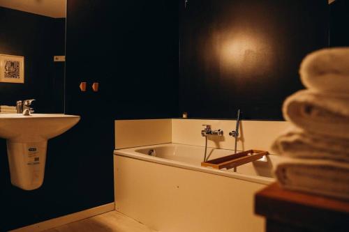 een badkamer met een wastafel en een bad naast een wastafel bij Liège City-Center TOP Duplex 8p - Pont d'Avroy in Luik