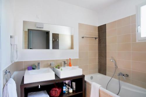 a bathroom with a sink and a tub and a mirror at Lagrange Vacances - Le Clos Savornin in Saint-Saturnin-lès-Apt