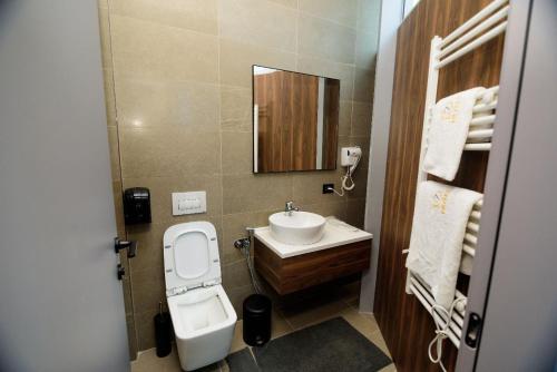 a bathroom with a sink and a toilet and a mirror at Hotel Zeneli Vlore in Vlorë