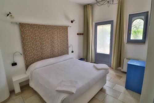 1 dormitorio con cama blanca y ventana en Masseria Trullo Sovrano Exclusive B&B, en Cisternino