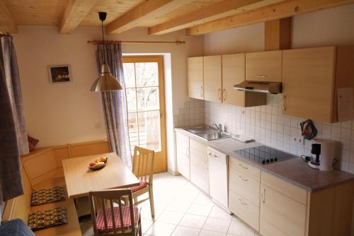 a small kitchen with a table and a table and chairs at Heinzenhof in Nova Levante