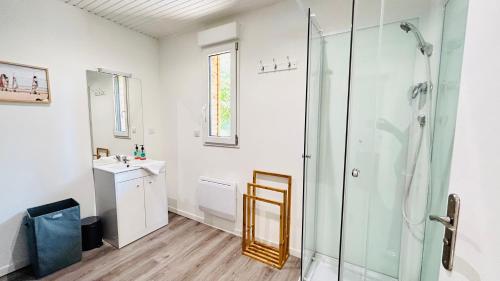 a bathroom with a shower and a sink and a mirror at Chalet avec terrasse sur pilotis vue sur l'étang in Rue