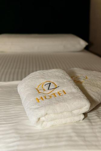 a towel with the name of a hotel on a bed at Hotel Zeneli Vlore in Vlorë