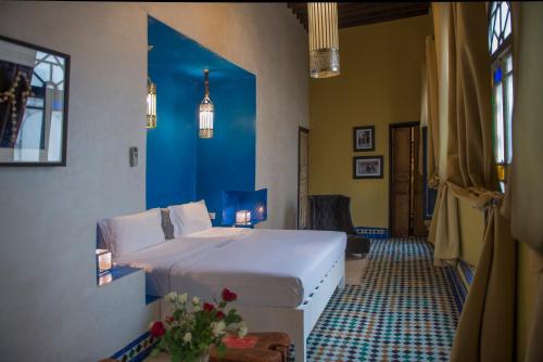 1 dormitorio con cama blanca y pared azul en Riad Palais Bahia Fes en Fez