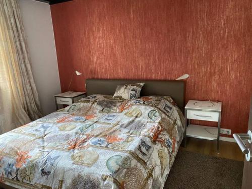 a bedroom with a bed and a red wall at Ferienwohnung Thalia in Berg am Starnberger See