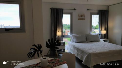 um quarto com uma cama e duas janelas em Sttanze Giardino em Posadas