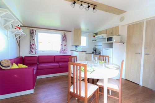 a living room with a purple couch and a table at Le Clos Tranquille in Saint-Cast-le-Guildo