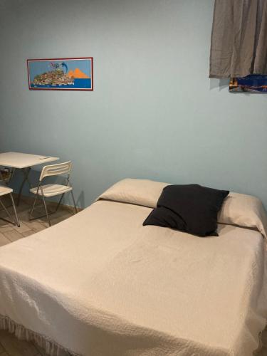 ナポリにあるMini Loftのテーブルと椅子が備わる客室のベッド1台分です。