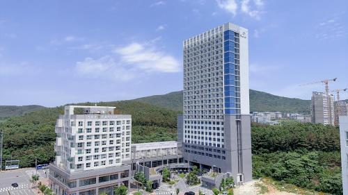 a tall building with blue windows in a city at Yongjiong Shine Hotel in Incheon