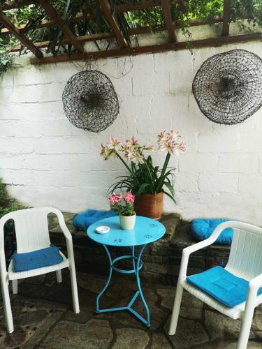 un patio con 2 sillas y una mesa con una planta en Maria's Studios pink, en Áfissos
