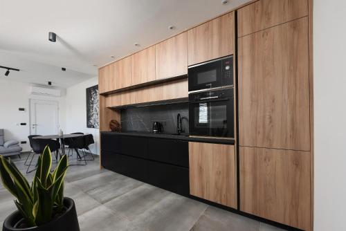 a kitchen with wooden cabinets and a black appliances at Luxury apartment N in Zadar