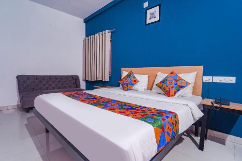 sypialnia z dużym łóżkiem z niebieską ścianą w obiekcie FabHotel Shri Ragavi Gardens w mieście Pīlamedu