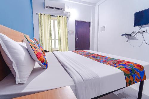a bedroom with a bed and a television in it at FabHotel Shri Ragavi Gardens in Pīlamedu
