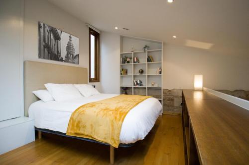 Un dormitorio con una gran cama blanca y un estante en Apartamentos Turísticos Pacios, en Santiago de Compostela