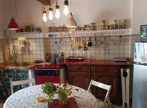 una cucina con tavolo e stufa rossa di Chambre Cassis a Arles