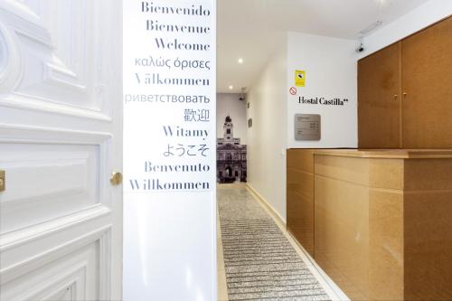 a hallway with a door and a wall with writing on it at Hostal Castilla II Puerta del Sol in Madrid