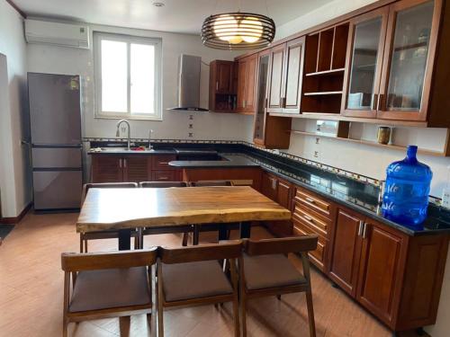 a kitchen with a wooden table and a kitchen with a sink at citybay homestay ha long 3BR in Ha Long
