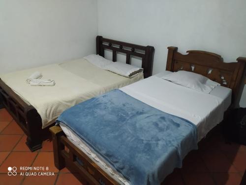 duas camas sentadas uma ao lado da outra num quarto em Cabaña villa lola em San Gil