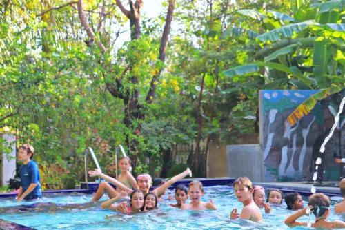 a group of children in a swimming pool at Levona Garden Resort in Habarana