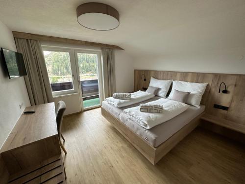 Un dormitorio con una cama grande y una ventana en Appartement Ski-Willy, en Ramsau am Dachstein