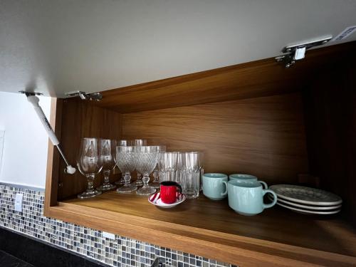 a wooden shelf with glasses and plates on it at Hotel APART Zuccolotto 2 in Aracruz