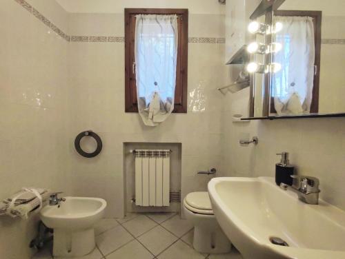 Baño blanco con lavabo y aseo en La Casa di Sciano, en Certaldo