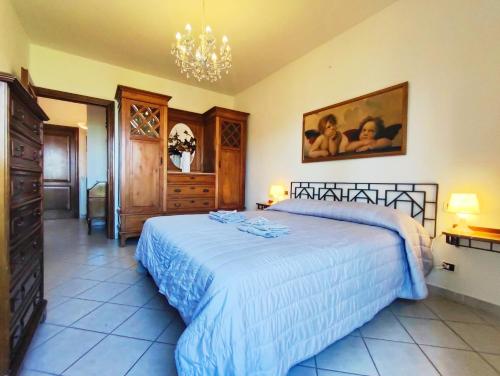 1 dormitorio con cama y lámpara de araña en La Casa di Sciano, en Certaldo