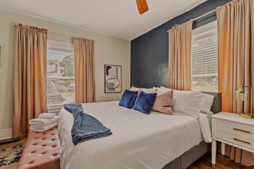 a bedroom with a large white bed with blue pillows at The Luxe/Hot Tub/12min to Horse Park/30 Min to Ark in Georgetown