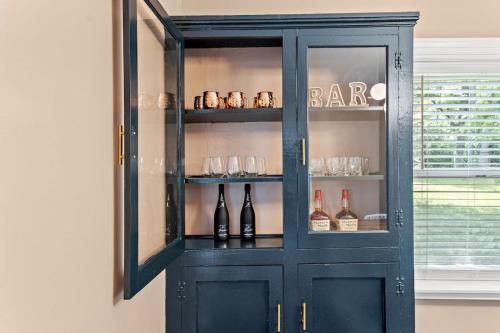 a blue cabinet with bottles and glasses in it at The Luxe/Hot Tub/12min to Horse Park/30 Min to Ark in Georgetown