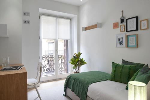 a white bedroom with a bed and a window at Easo Suite 2B by FeelFree Rentals in San Sebastián