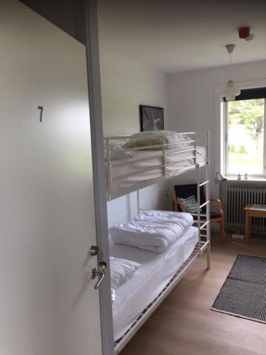 a room with two bunk beds and a window at Aktivitetshuset Solhjem in Hjørring