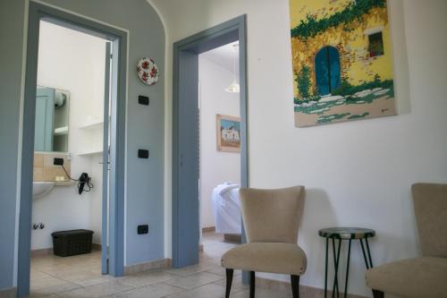 a living room with a chair and a mirror at Masseria Trullo Sovrano Exclusive B&B in Cisternino