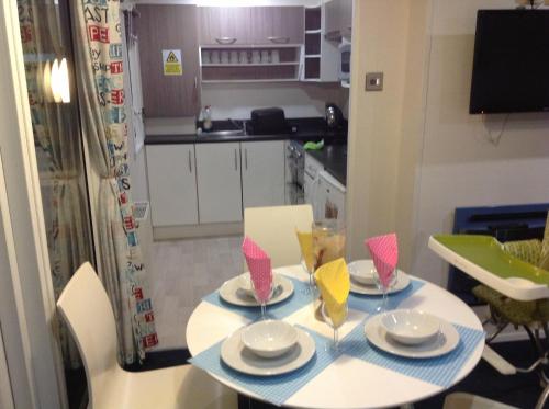 a small kitchen with a table with plates and napkins at Ritz Summerhouse in Hastings
