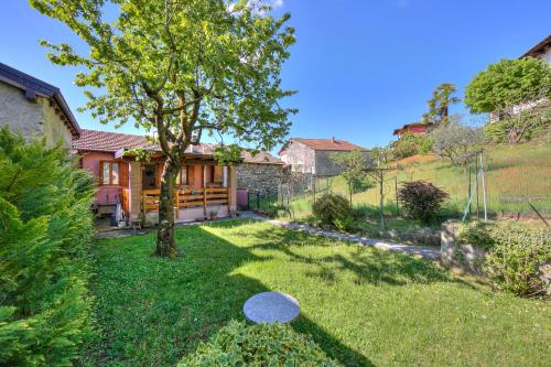 ein Haus mit einem Baum im Hof in der Unterkunft Brighty Rainbow House Garden - Happy Rentals in Armeno
