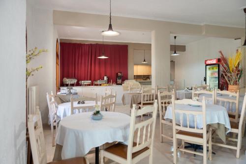 a dining room with white tables and white chairs at ALEXANDROS B in Nikiana