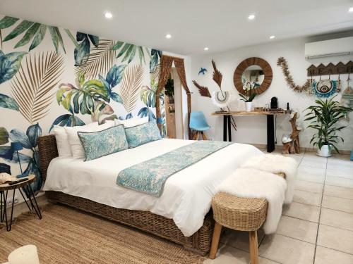 - une chambre avec un grand lit et du papier peint tropical dans l'établissement Le Nid Bleu, au Beausset