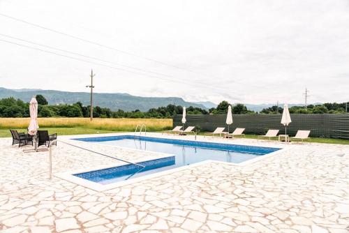 a swimming pool with chairs and a table at Pool & River House - Lazara in Danilovgrad