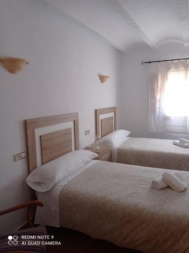 Cette chambre comprend 2 lits et une fenêtre. dans l'établissement Casa Rural Juan, el Zapa, à Letur