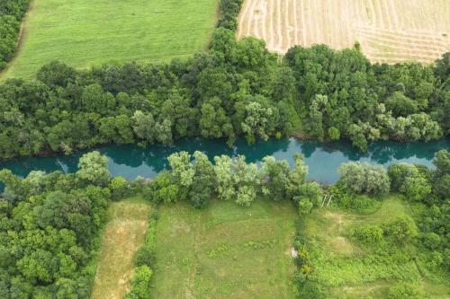 an aerial view of a river with trees and a field at Pool & River House - Lazara in Danilovgrad