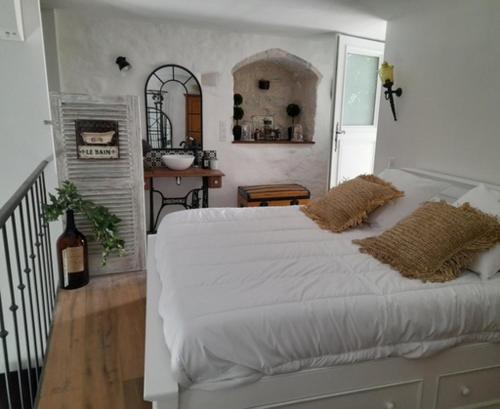 une chambre avec un grand lit blanc avec deux oreillers dans l'établissement L Estello, Village house in Provence, à Seillans